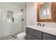 Modern bathroom featuring a glass-enclosed shower, sleek vanity, and decorative rustic mirror at 1949 E Oxford Dr, Tempe, AZ 85283
