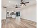 Open-concept living space with wood-look flooring, ceiling fans, and kitchen island at 1949 E Oxford Dr, Tempe, AZ 85283