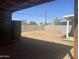 Spacious dirt backyard with cinderblock perimeter fence, under covered patio, offering privacy and development opportunity at 2010 N 38Th Ave, Phoenix, AZ 85009