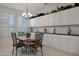 Charming dining area with elegant chandelier, table seating four, and ample white cabinets for storage at 20416 N Palm Canyon Dr, Surprise, AZ 85374