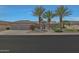 Well-maintained home featuring desert landscaping and a three car garage at 20416 N Palm Canyon Dr, Surprise, AZ 85374
