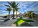 Beautiful desert-landscaped front yard with lush green patches and majestic palm trees leading to a modern home at 20416 N Palm Canyon Dr, Surprise, AZ 85374