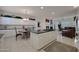 Open-concept kitchen featuring white cabinets, a central island with cooktop, and a seamless transition to living area at 20416 N Palm Canyon Dr, Surprise, AZ 85374