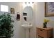 Powder room features a pedestal sink, decorative mirror, potted plant and decorative baskets at 20416 N Palm Canyon Dr, Surprise, AZ 85374