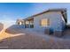 Home exterior with a covered patio, sliding doors, and air conditioning units, ensuring comfort and style at 21422 W Meadowbrook Ave, Buckeye, AZ 85396