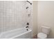 Bright bathroom showcases a tiled shower-tub, matte black fixtures, and a sleek toilet at 21422 W Meadowbrook Ave, Buckeye, AZ 85396