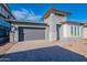 Beautiful single-story home featuring a gray exterior, gray garage door, desert landscaping and a paver driveway at 21422 W Meadowbrook Ave, Buckeye, AZ 85396
