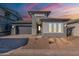 Beautiful single-story home featuring a gray exterior, gray garage door, desert landscaping and a paver driveway at 21422 W Meadowbrook Ave, Buckeye, AZ 85396