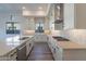 Bright, open kitchen featuring stainless appliances, gorgeous tile backsplash, wood flooring and an island at 21422 W Meadowbrook Ave, Buckeye, AZ 85396