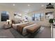 Tranquil staged bedroom with neutral tones, large windows offering stunning mountain views at 21422 W Meadowbrook Ave, Buckeye, AZ 85396