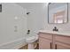 Cozy bathroom with a shower-tub combo, vanity with modern fixtures, and updated tiling around the floor at 2411 W Oberlin Way, Phoenix, AZ 85085