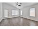 Light-filled living room with wood flooring, ceiling fan, and multiple windows at 2411 W Oberlin Way, Phoenix, AZ 85085