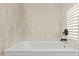 Bathtub with updated tile surround and brushed bronze fixtures at 2938 N 15Th Ave, Phoenix, AZ 85015