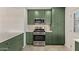 Kitchen featuring stainless steel appliances, green cabinets, light countertops and tile backsplash at 2938 N 15Th Ave, Phoenix, AZ 85015