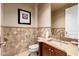 Powder room with beautiful earth tone tile surround, vanity with sink and a mirror at 37015 N 27Th Pl, Cave Creek, AZ 85331