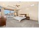 Spacious bedroom with tray ceiling, ceiling fan, and sliding glass door to backyard at 37015 N 27Th Pl, Cave Creek, AZ 85331