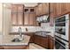 Close up of gas range cooktop, oven, and custom cabinetry in kitchen at 37015 N 27Th Pl, Cave Creek, AZ 85331
