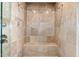 An elegant shower with a built-in seat and travertine tile, offering a spa-like experience at 37015 N 27Th Pl, Cave Creek, AZ 85331