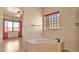 Elegant bathroom featuring a marble corner tub and a unique glass block window for natural light at 40108 N 2Nd Way, Phoenix, AZ 85086