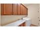 Functional laundry room with sink, counter space, and ample storage cabinets above washer and dryer at 40108 N 2Nd Way, Phoenix, AZ 85086