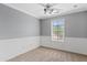 Cozy bedroom with wainscoting, a ceiling fan, and a large window at 4098 E Rustler Way, Gilbert, AZ 85297