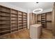 Spacious walk-in closet with custom shelving, center island, and modern lighting at 4318 E Cheery Lynn Rd, Phoenix, AZ 85018