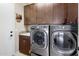 Laundry room with upper cabinets, front loading washer and dryer at 4710 E Tierra Buena Ln, Phoenix, AZ 85032