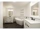 Modern bathroom boasts dual sink vanity, soaking tub, built-in shelving and modern fixtures at 4836 N 72Nd Way, Scottsdale, AZ 85251