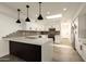 Bright kitchen boasts a breakfast bar, modern stainless appliances, stone countertops and grey tile backsplash at 4836 N 72Nd Way, Scottsdale, AZ 85251