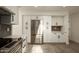 Modern kitchen with stainless appliances, stainless refrigerator, white cabinets, grey backsplash and stone countertops at 4836 N 72Nd Way, Scottsdale, AZ 85251