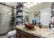 Bathroom with a tiled shower and granite vanity, offering both style and functionality at 4855 W Turquoise Ave, Glendale, AZ 85302