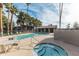 Resort-style pool and hot tub surrounded by mature palm trees, lounge seating, and a covered structure at 533 W Guadalupe Rd # 1068, Mesa, AZ 85210
