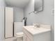 Bathroom with white tile, sink, and white cabinets, plus stacked washer and dryer at 5339 N Black Canyon Hwy, Phoenix, AZ 85015