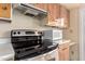 Stainless steel stove, microwave, and a range hood, all complemented by wooden cabinets at 5339 N Black Canyon Hwy, Phoenix, AZ 85015