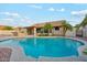 Inviting backyard with a sparkling pool, a built-in outdoor kitchen, and lush landscaping for a private retreat at 5830 W Cinnabar Ave, Glendale, AZ 85302