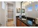 Well-lit bathroom with a dark granite countertop, custom cabinetry, framed mirrors, and a separate bathing area at 6522 N 27Th St, Phoenix, AZ 85016