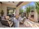 Desert view from a covered patio with comfortable seating around a modern fireplace, a water feature and lots of foliage at 6522 N 27Th St, Phoenix, AZ 85016