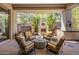 Inviting covered patio with a fireplace and seating arrangement, surrounded by lush desert landscaping and a water feature at 6522 N 27Th St, Phoenix, AZ 85016