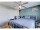 This primary bedroom offers a comfortable sleeping space with natural light and neutral decor with light blue accent wall at 701 N 95Th Cir, Mesa, AZ 85207
