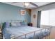 This primary bedroom offers a comfortable sleeping space with natural light and light blue accent wall at 701 N 95Th Cir, Mesa, AZ 85207