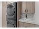 Modern laundry room features front loading washer and dryer unit, and light wood cabinets, sink and granite countertop at 7157 E Rancho Vista Dr # 3001, Scottsdale, AZ 85251