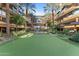 A picturesque courtyard featuring a mini putting green with palm trees and upscale condos in the background at 7157 E Rancho Vista Dr # 3001, Scottsdale, AZ 85251