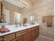Bathroom featuring double sinks, wood cabinets and Southwestern themed decor at 7214 N 88Th Ln, Glendale, AZ 85305
