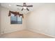 Well-lit bedroom featuring natural light, ceiling fan, and neutral carpet at 7214 N 88Th Ln, Glendale, AZ 85305