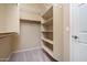 Walk-in closet with built-in shelving and carpet for optimal storage space at 7214 N 88Th Ln, Glendale, AZ 85305