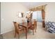 Inviting dining room featuring neutral paint, carpet flooring, wood furniture, and decorative curtains at 7214 N 88Th Ln, Glendale, AZ 85305