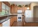 Well-lit kitchen featuring wooden cabinets, modern appliances, a breakfast bar, and a window overlooking the yard at 7214 N 88Th Ln, Glendale, AZ 85305