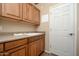 Laundry room featuring a sink, storage and convenient access to the outdoors at 7214 N 88Th Ln, Glendale, AZ 85305