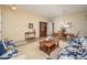 Inviting living room featuring tile flooring, neutral paint, wood furniture, and blue sofas at 7214 N 88Th Ln, Glendale, AZ 85305