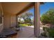 A covered patio looks out onto a manicured backyard with lush greenery at 7214 N 88Th Ln, Glendale, AZ 85305